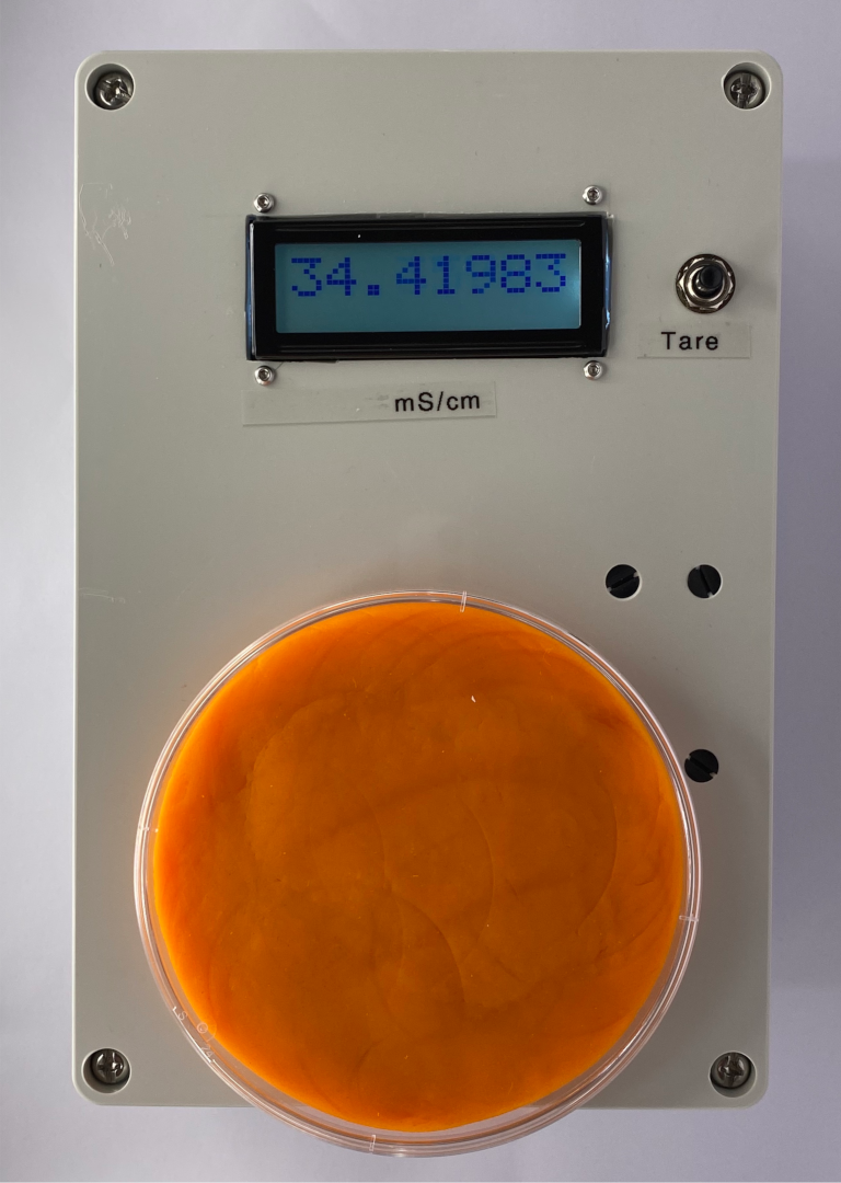 TC-X1 showing a reading of 31.96 mS/cm with orange plah-doh in a petri dish on the sensor